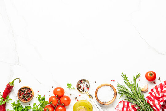 Kitchen table with herbs, spices and vegetables.