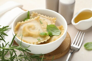 Delicious ravioli with basil served on light table, closeup