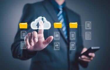 Businessman using cloud storage and digital folders for data management, upload, and file sharing, representing technology, cybersecurity, and modern business information systems. © loechai