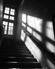 Stairs illuminated by sunlight casting shadows on the walls.