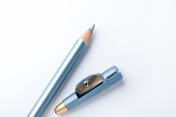 Light blue eye liner and sharpener on white background, top view