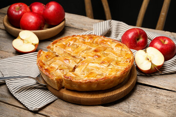 Delicious homemade pie and apples on wooden table, closeup