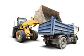 A powerful loader lifts dirt and debris, transferring it into a waiting dump truck. The scene captures the dynamic nature of construction work on a clear background.