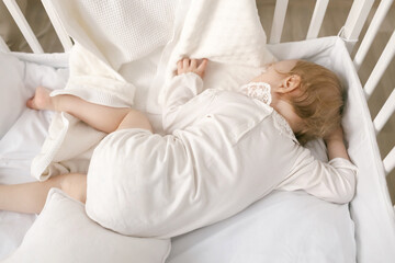 Baby to sleep by rocking him, mom holds the baby in her arms gently hugging and kissing him, mother and child, healthy sleep of the child with the mother.