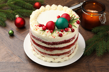 Delicious sponge cake with Christmas decor and red currants on wooden table, closeup