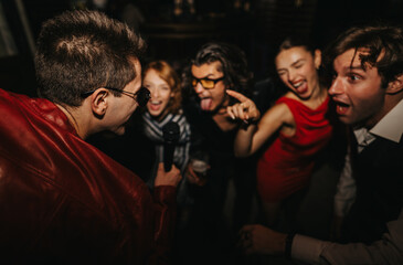 A lively night out with friends enjoying music, singing into a microphone, and dancing in a dark venue. Their energy and smiles capture celebration, togetherness, and social fun.