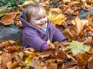 Baby spielt vergn&uuml;gt im Herbstlaub