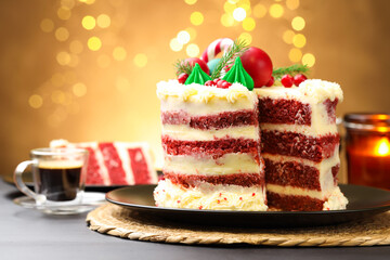 Tasty cake with Christmas decor on black table against blurred lights, closeup
