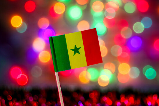 Senegal flag with green star and colorful bokeh background. Symbol of independence, West African pride, and the vibrant culture of Dakar and Goree Island.