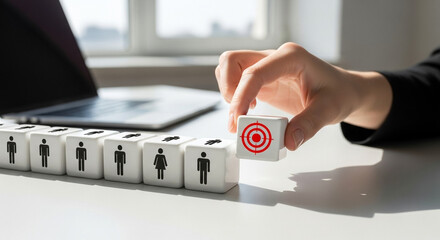 Hand placing target cube among human icons on desk in bright office, recruitment strategy and best candidate selection