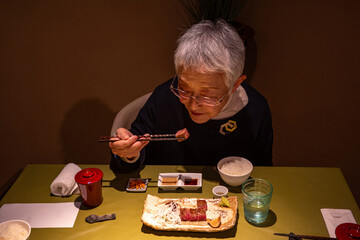 レストランでディナーを食す老婦人