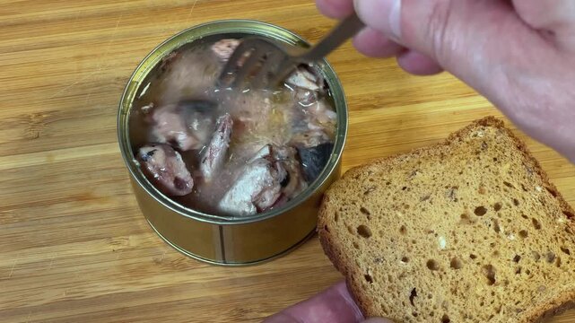 Laying out canned fish from tin to piece of bread