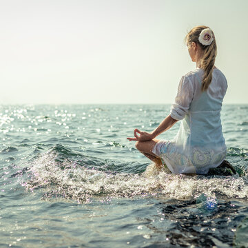 Woman meditating at the sea