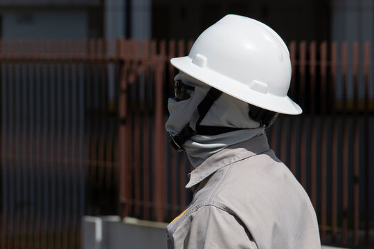 Retrato de trabalhador da constru&ccedil;&atilde;o civil com balaclava, &oacute;culos escuros e equipamentos de seguran&ccedil;a trabalhando em manuten&ccedil;&atilde;o de rede de alta tens&atilde;o