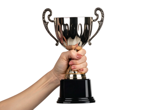 A person's hand raises a shiny, metallic cup with ornate handles, set against a solid black background. The cup rests on a dark rectangular base