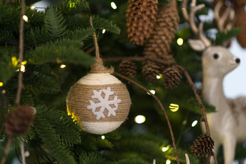 cozy New Year's toy layer of threads and a snowflake Christmas ball against a Christmas tree. Merry Christmas and Happy New Year