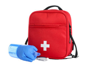 A red first aid bag with a white cross sits upright. Next to it, a gloved hand holds a blue medical device