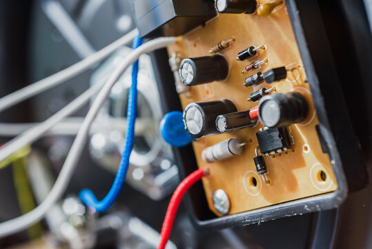 Disassembled broken electric multicooker with wires and capacitor, closeup photo. Close-up of motherboard inside opened multicooker