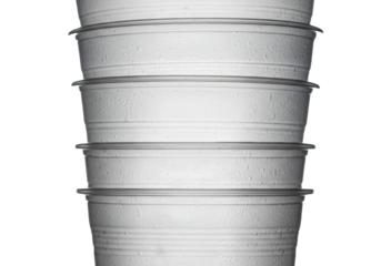 close-up macro shot of vertically stacked frosted translucent pet plastic drink cups emphasizing structural ridges against a transparent studio background. concept of industrial material science