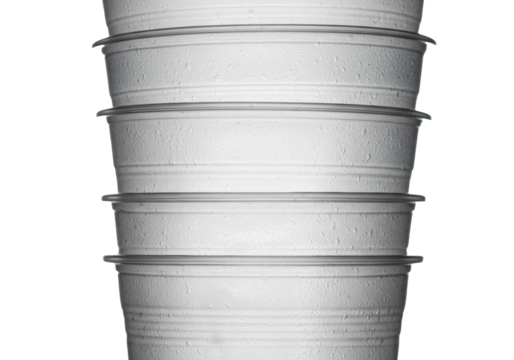 close-up macro shot of vertically stacked frosted translucent pet plastic drink cups emphasizing structural ridges against a transparent studio background. concept of industrial material science