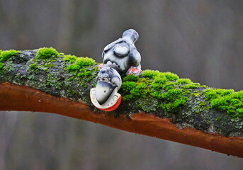 A toy crow and cheese on a stump in an autumn forest on a cloudy day.