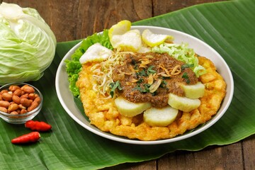 Tahu tek, tahu gunting, tahu telur is a typical Surabaya food consisting of fried tofu, rice cake, fried potatoes, bean sprouts and cucumber, which are drizzled with peanut sauce.