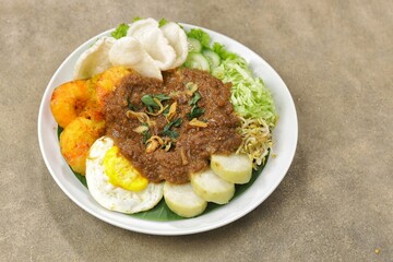 Tahu gimbal is a dish consisting of fried tofu, shredded raw cabbage, rice cake, bean sprouts, eggs, and gimbal mixed with a distinctive peanut sauce because it uses shrimp paste.