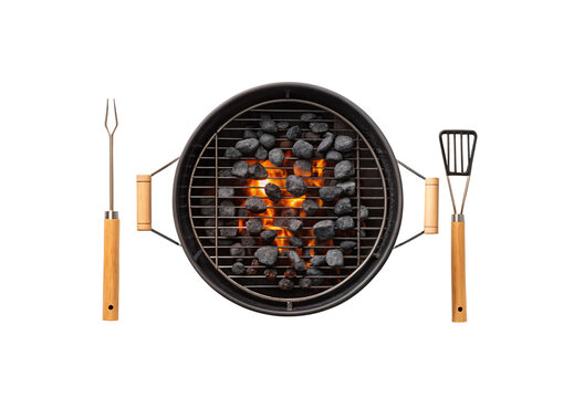 Round black grill with cooking utensils fork and spatula positioned beside burning coals, isolated on a transparent background