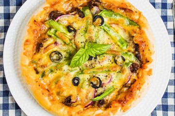 Deliciously topped vegetable pizza on a white plate