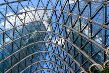 Fototapeta premium Beneath the elegant glass arches, sunlight dances in a modern architectural marvel