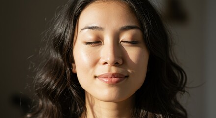 Closeup portrait of a serene asian woman with closed eyes enjoying sunlight