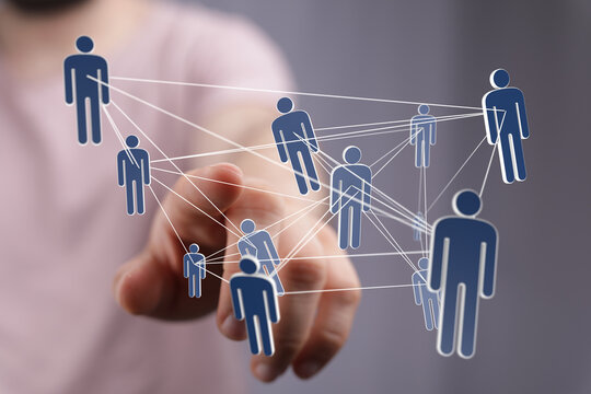 Hand interacting with a digital network of people, symbolizing teamwork and global connection.