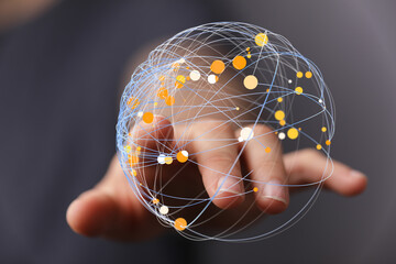 Abstract image of a person's hand holding a digital globe, representing global connectivity,...