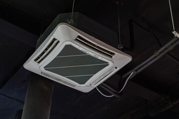 Four-way air conditioner installed under the hall ceiling for cooling the room.