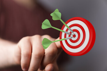Image of a dartboard with three darts hitting the bullseye, representing success, accuracy, and the...