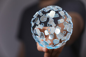 An artistic image of a hand holding a glowing digital sphere composed of chat bubbles, representing...