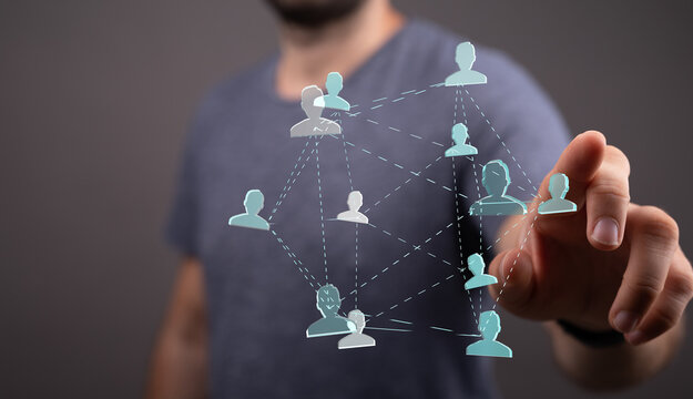 A man's hand touching a network of connected human icons symbolizing social connection, communication and global concepts - Powered by Adobe