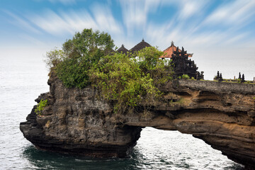 The natural rock arch at the Pura Batu Bolong near Tanah Lot Temple in Bali, Indonesia
