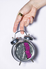 Male hand holding metallic alarm clock