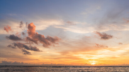 Sunset sky clouds over sea water background in evening with orange, blue sun light, Horizon sea ocean sunrise sky landscape nature backgrounds and gold sun down in golden hour summer season, Dusk sky