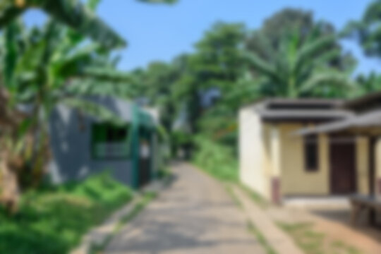 Defocused and blurred abstract background of a quiet suburban street with houses and trees