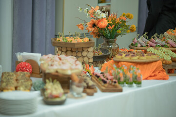 Elegant buffet table with appetizers and orange flower decor