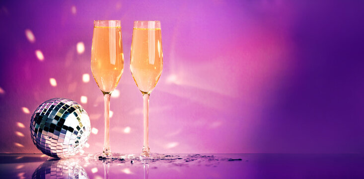 Celebration, festive, party time concept. Champagne glasses, disco ball on shining pink background. Valentines day, New year's eve, Birthday invitation.