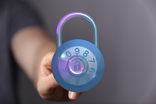 A futuristic padlock glows with neon light, held in a hand, symbolizing digital security and data protection. Concept of cybersecurit - Powered by Adobe