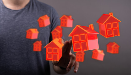 Abstract image of a person interacting with 3D rendered red houses. Concept of property investment,...