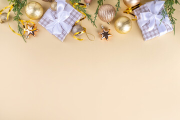 Golden baubles Christmas, New Year background with golden christmas tree twigs and balls, holiday gift boxes, decorations, tablet notepad flat lay on pink background copy space