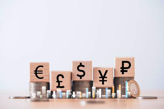 Stacked coins with wooden blocks showing global currency symbols representing financial growth exchange rate investment forex trading and international economy concept. - Powered by Adobe
