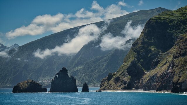 A mountain range with a cloudy sky in the background