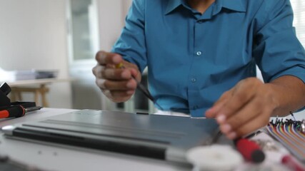 Electronic technician repairing laptop computer.