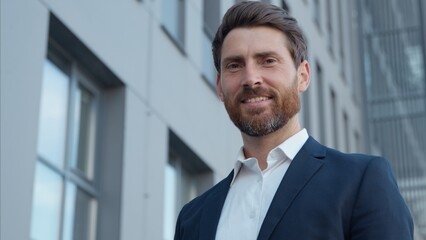 Portrait Caucasian mature business man smiling looking at camera in city posing successful adult...